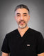 Dr. Zadeh wearing a black scrub top against a gray background