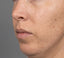 Close-up of a person's face with a neutral expression on a gray background