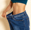 Person wearing a blue crop top and oversized jeans on a beige background